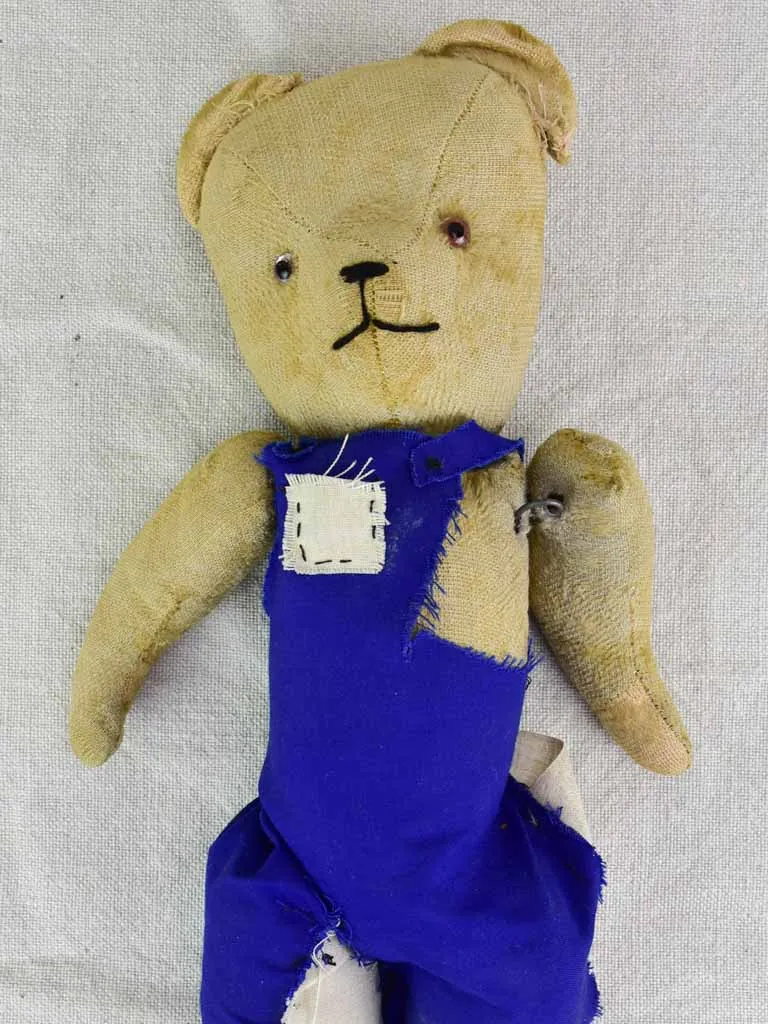 Antique French teddy bear with blue overalls