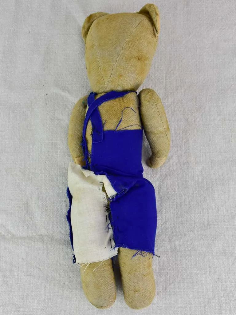 Antique French teddy bear with blue overalls